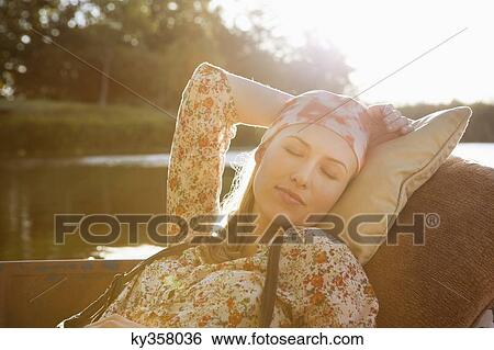 Stock Photograph - Beautiful woman sleeping in the boat. Fotosearch