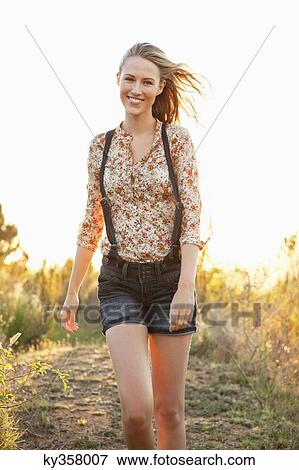 Beautiful woman walking on a trail and smiling View Large Photo Image Stock Photo - Beautiful woman walking on a trail and smiling. Fotosearch