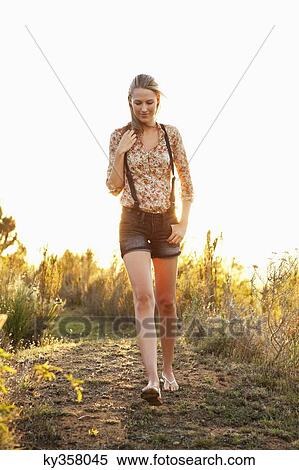 Stock Photography - Beautiful woman walking on a trail and smiling. Fotosearch