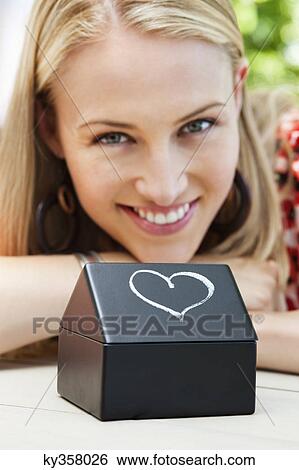 Stock Photograph - Close-up of a model home with a woman smiling. Fotosearch