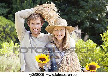 Portrait of a couple in scarecrow pose in a field View Large Photo Image Stock Photograph - Portrait of a couple in scarecrow pose in a field. Fotosearch