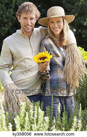 Portrait of a couple in scarecrow pose in a field View Large Photo Image Stock Photograph - Portrait of a couple in scarecrow pose in a field. Fotosearch