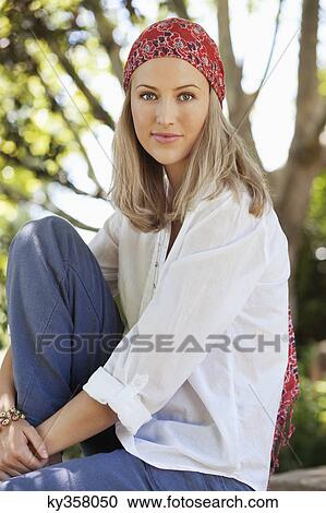 Stock Image - Smiling young woman wearing bandana. Fotosearch