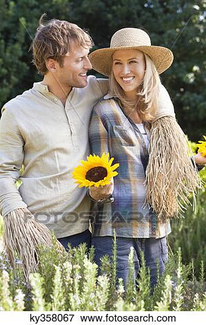 Young couple in scarecrow pose in a field View Large Photo Image Stock Photo - Young couple in scarecrow pose in a field. Fotosearch