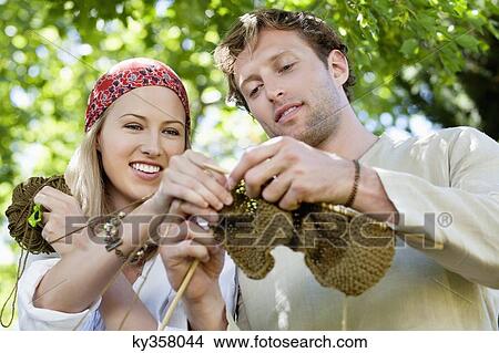 Picture - Young couple knitting together and smiling. Fotosearch