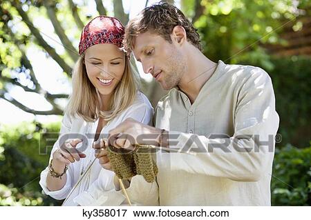 Young couple knitting together and smiling View Large Photo Image Stock Photo - Young couple knitting together and smiling. Fotosearch
