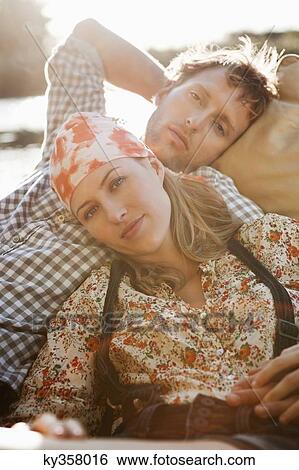 Stock Photograph - Young couple resting in the boat. Fotosearch