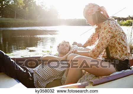 Stock Image - Young couple romancing in the boat. Fotosearch