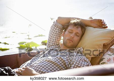 Young man sleeping in the boat View Large Photo Image Stock Photo - Young man sleeping in the boat. Fotosearch