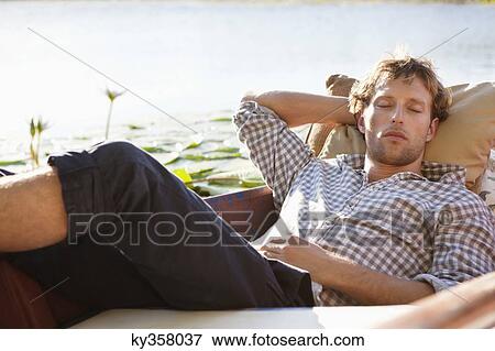 Young man sleeping in the boat View Large Photo Image Stock Photo - Young man sleeping in the boat. Fotosearch