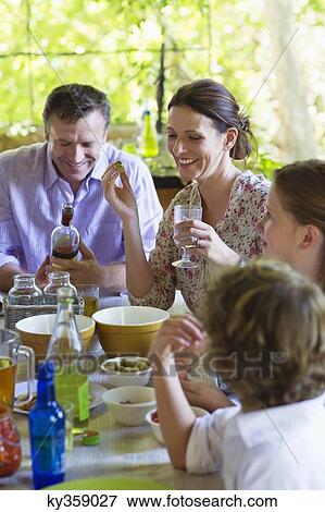 Family having food at home with their two children View Large Photo Image Stock Photo - Family having food at home with their two children . Fotosearch
