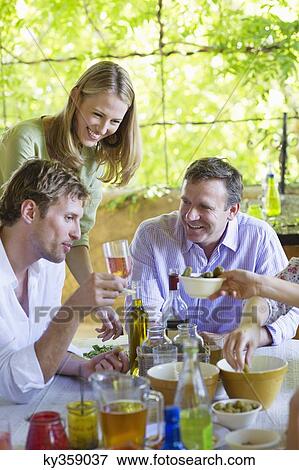 Stock Photo - Happy family having drink at home. Fotosearch