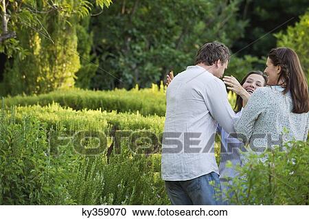 Mature couple hugging their mother in a garden View Large Photo Image Stock Image - Mature couple hugging their mother in a garden. Fotosearch
