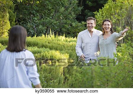Stock Photography - Mature couple walking towards their mother in a garden. Fotosearch
