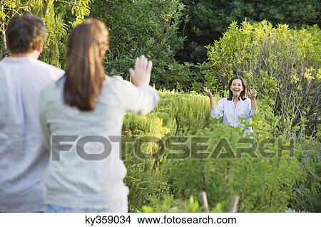 Mature couple waving hand to their mother in a garden View Large Photo Image Picture - Mature couple waving hand to their mother in a garden. Fotosearch