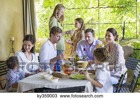 Stock Image - Multi generation family eating food at house. Fotosearch
