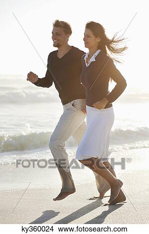 Couple running on the beach View Large Photo Image Picture - Couple running on the beach. Fotosearch