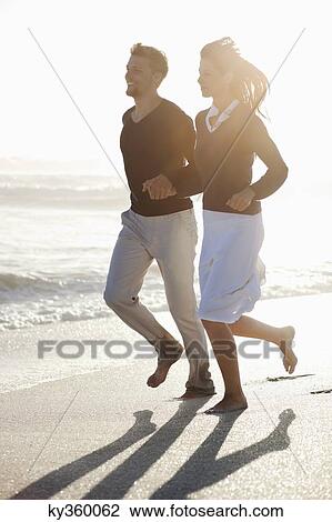 Couple running on the beach View Large Photo Image Stock Image - Couple running on the beach. Fotosearch