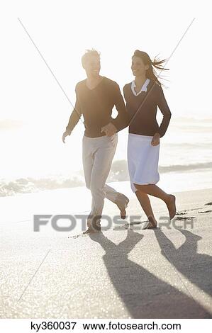 Stock Photo - Couple running on the beach. Fotosearch