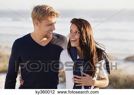 Stock Image - Couple talking on beach. Fotosearch