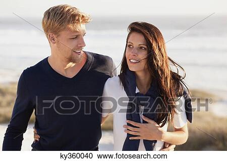 Stock Image - Couple talking on beach. Fotosearch