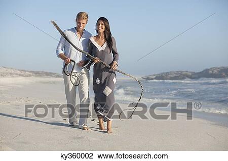 Couple walking on the beach View Large Photo Image Stock Image - Couple walking on the beach. Fotosearch