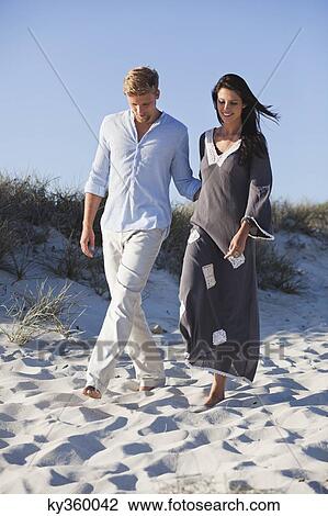 Stock Image - Couple walking on the beach. Fotosearch