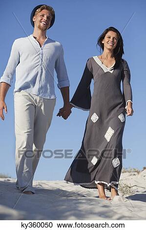 Couple walking on the beach View Large Photo Image Stock Image - Couple walking on the beach. Fotosearch