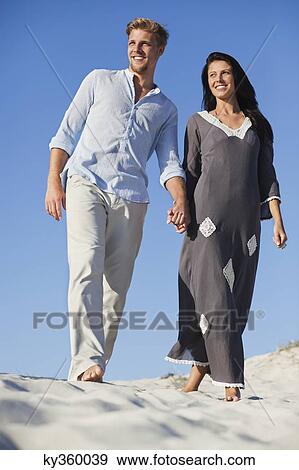 Stock Photo - Couple walking on the beach. Fotosearch