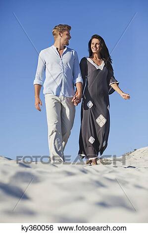 Couple walking on the beach View Large Photo Image Stock Photograph - Couple walking on the beach. Fotosearch