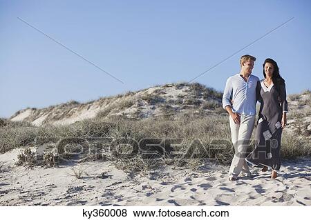 Stock Photo - Couple walking together on the beach. Fotosearch