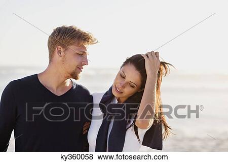 Stock Photo - Man looking at his girlfriend on beach. Fotosearch