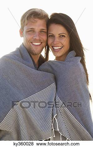 Portrait of a couple wrapped in a blanket View Large Photo Image Stock Photo - Portrait of a couple wrapped in a blanket. Fotosearch