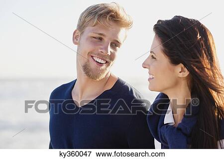 Young couple looking at each other and smiling View Large Photo Image Stock Photo - Young couple looking at each other and smiling. Fotosearch