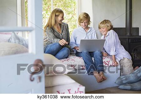 Stock Photo - Children and their mother using laptop at house. Fotosearch