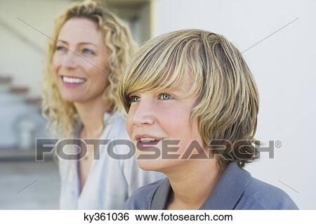 Stock Photograph - Close-up of a teenage boy smiling with his mother. Fotosearch