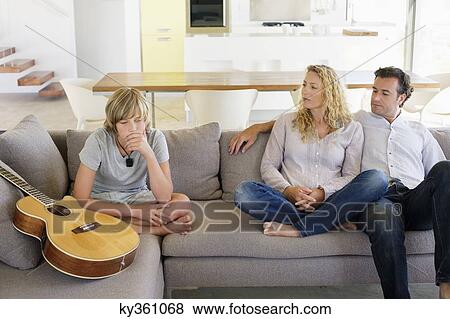 Stock Photo - Couple looking at their son looking sad. Fotosearch
