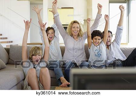 Family watching television set together at home View Large Photo Image Picture - Family watching television set together at home. Fotosearch
