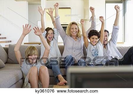 Family watching television set together at home View Large Photo Image Stock Photograph - Family watching television set together at home. Fotosearch