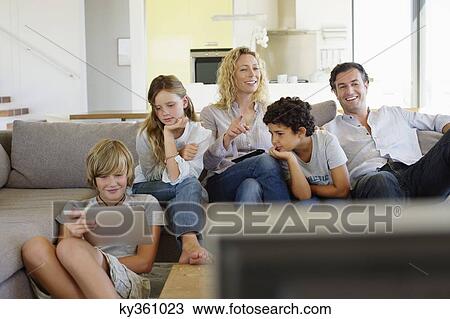 Family watching TV together at home View Large Photo Image Stock Image - Family watching TV together at home. Fotosearch