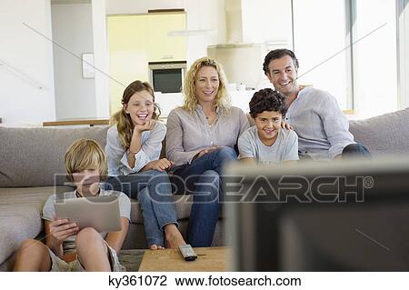 Family watching TV together at home View Large Photo Image Stock Image - Family watching TV together at home. Fotosearch