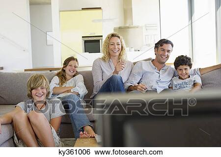Family watching TV together at home View Large Photo Image Stock Photograph - Family watching TV together at home. Fotosearch