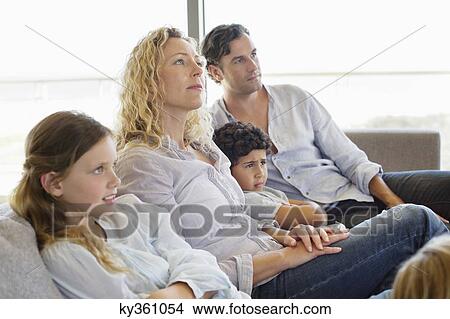 Family with three children sitting on a couch View Large Photo Image Picture - Family with three children sitting on a couch. Fotosearch