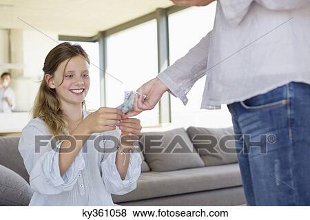 Girl taking paper currency from her mother View Large Photo Image Stock Photo - Girl taking paper currency from her mother. Fotosearch