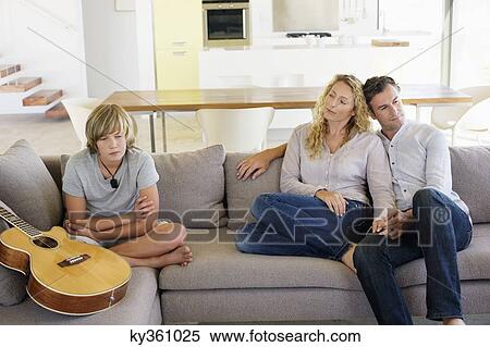Teenage boy sitting with a guitar on a couch View Large Photo Image Stock Photography - Teenage boy sitting with a guitar on a couch. Fotosearch