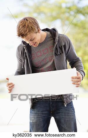 Man looking at a blank placard View Large Photo Image Stock Photography - Man looking at a blank placard. Fotosearch