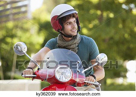 Man riding a scooter View Large Photo Image Stock Photo - Man riding a scooter. Fotosearch