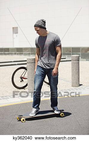 Stock Image - Man skateboarding on the road. Fotosearch