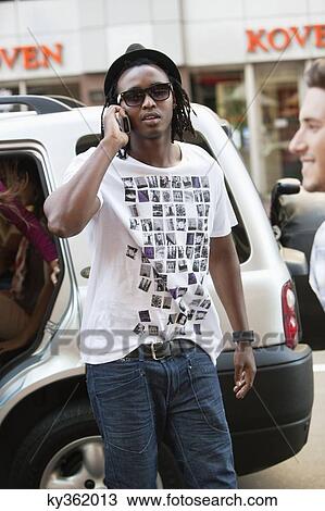 Man wearing hat and talking on a mobile phone View Large Photo Image Stock Image - Man wearing hat and talking on a mobile phone. Fotosearch