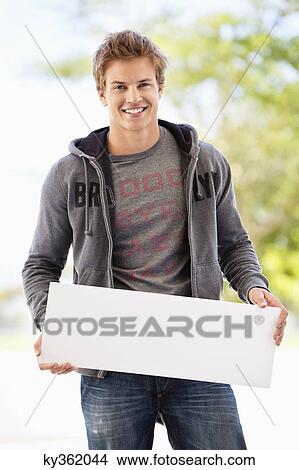Portrait of a man holding a blank placard View Large Photo Image Picture - Portrait of a man holding a blank placard. Fotosearch